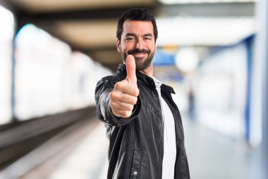 Deri ceket başparmak ile olan adam