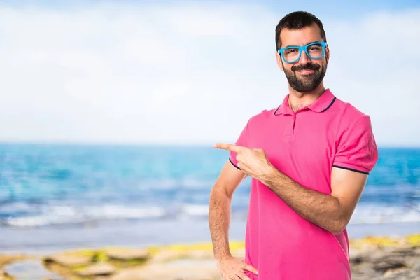 Homem com roupas coloridas apontando para a lateral — Fotografia de Stock