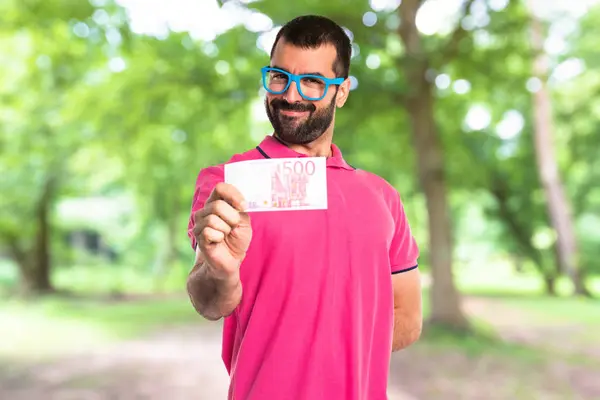 Pria dengan pakaian berwarna-warni mengambil banyak uang — Stok Foto
