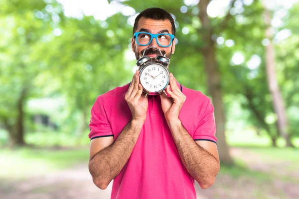 Man met kleurrijke kleding bedrijf vintage klok — Stockfoto