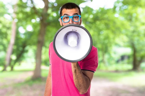 Man met kleurrijke kleding schreeuwen door megafoon — Stockfoto