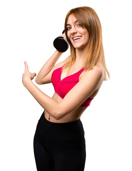 Красивая спортивная женщина с гантелями, указывающими назад — стоковое фото