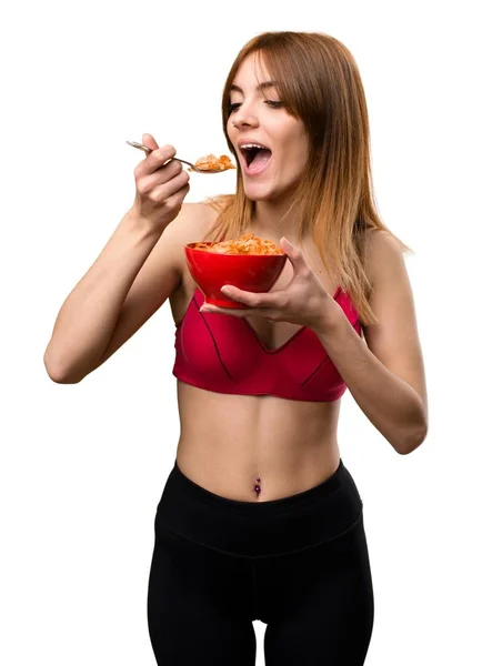 Giovane donna sportiva che mangia cereali da una ciotola — Foto Stock