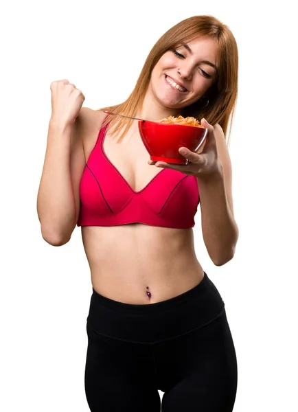 Młoda kobieta jedzenie zbóż z miski sportu — Zdjęcie stockowe