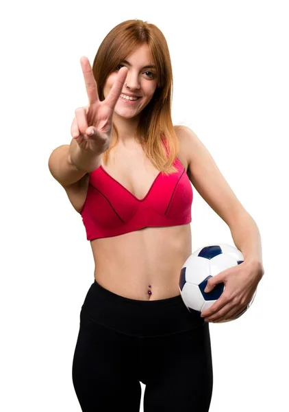 Νέος αθλητισμός γυναίκα που κρατά μια μπάλα ποδοσφαίρου — Φωτογραφία Αρχείου