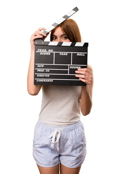 Bella ragazza in pigiama che tiene un clapperboard — Foto Stock