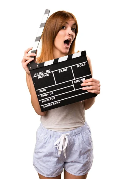 Beautiful girl in pajamas holding a clapperboard — Stock Photo, Image