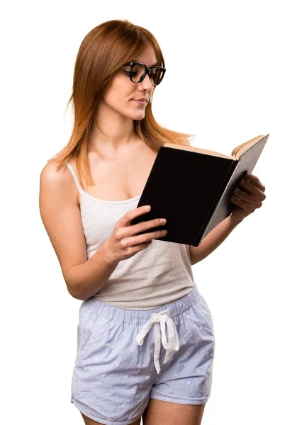 Vacker flicka i pyjamas läser bok — Stockfoto