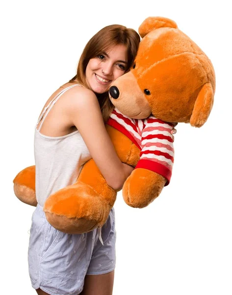 Bella ragazza in pigiama giocare con peluche — Foto Stock