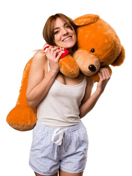 Krásná dívka v pyžamu hrající s vycpané zvíře — Stock fotografie