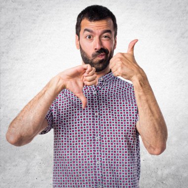 Yakışıklı adam iyi-kötü işaret yapma