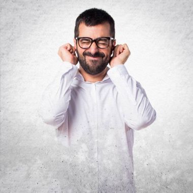 Kulakları kapsayan gözlüklü yakışıklı adam