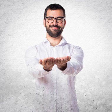 Gözlüklü bir şey tutan yakışıklı adam