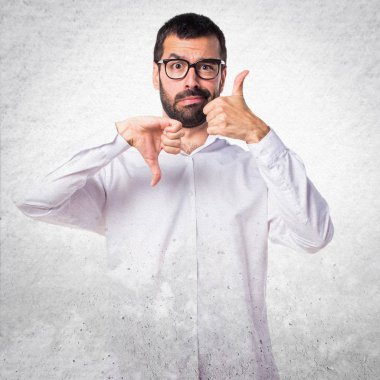 İyi-kötü işaret yapma gözlüklü yakışıklı adam