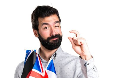 Birçok bayrak tutan ve küçük işareti yaparak sakallı yakışıklı adam