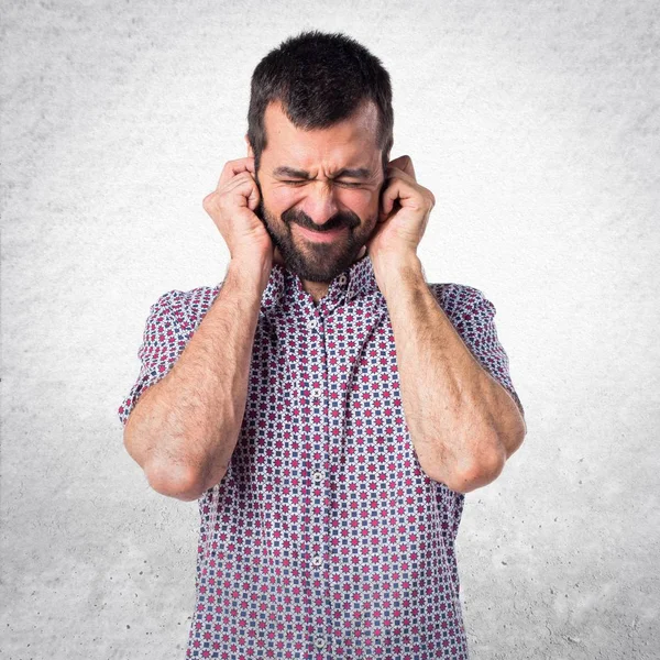 Handsome man covering his ears — Stock Photo, Image