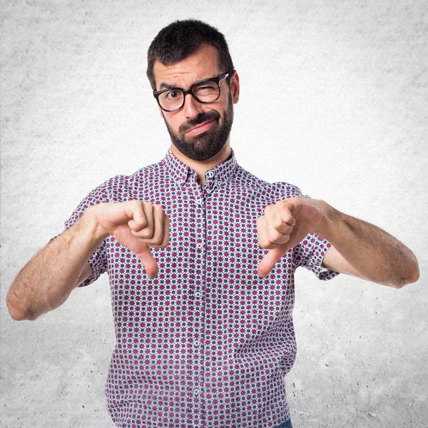 Hombre con gafas haciendo mala señal —  Fotos de Stock