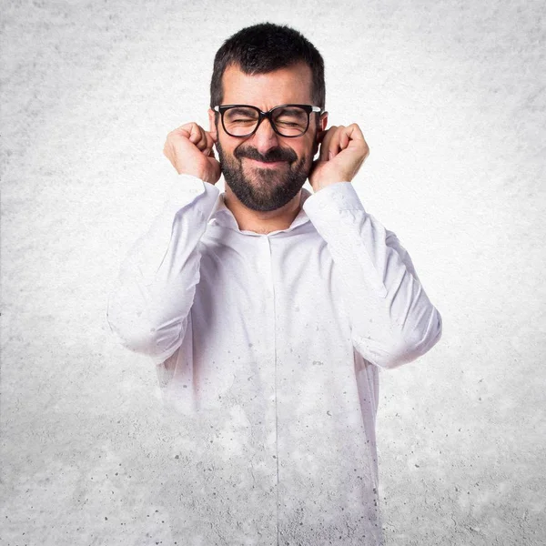 Kulakları kapsayan gözlüklü yakışıklı adam