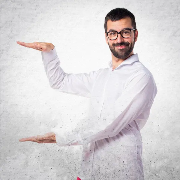 Gözlüklü bir şey tutan yakışıklı adam