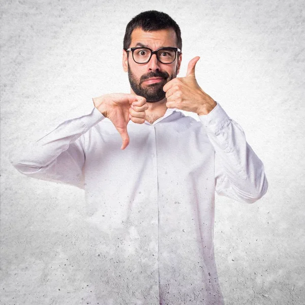 İyi-kötü işaret yapma gözlüklü yakışıklı adam