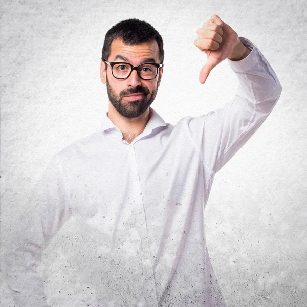 Handsome man with glasses doing bad signal — Stock Photo, Image