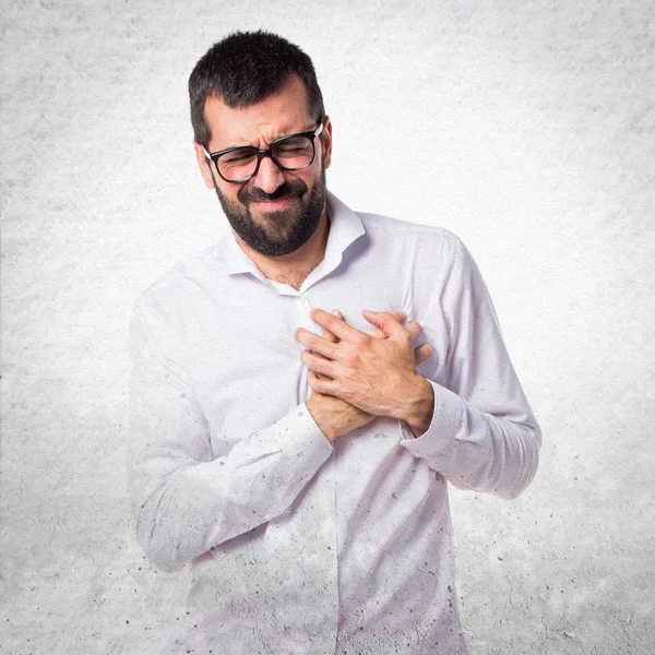 Beau homme avec des lunettes avec des douleurs cardiaques — Photo