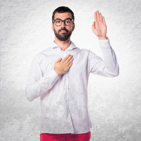 Hombre guapo con gafas haciendo un juramento — Foto de Stock