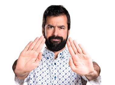 Dur işareti yapma sakallı yakışıklı esmer adam