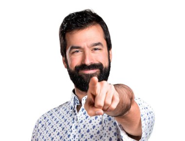 Öne doğru işaret eden sakallı yakışıklı esmer adam