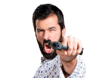 Bir tabanca tutan sakallı yakışıklı esmer adam