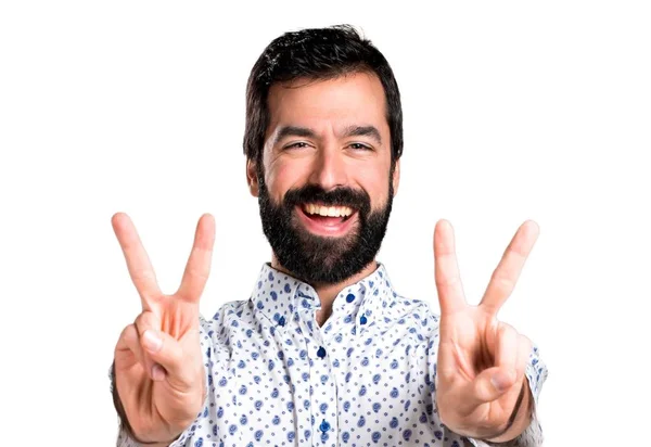Snygg brunett man med skägg gör seger gest — Stockfoto