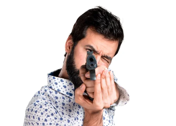 Szép barna férfi szakállal gazdaság egy pisztoly — Stock Fotó