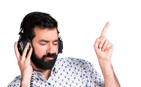 Handsome brunette man with beard listening music
