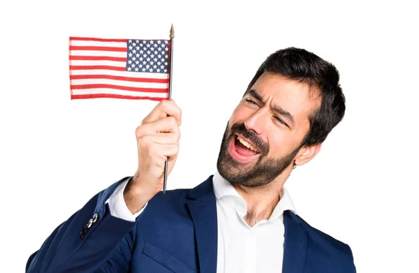 Bonito homem segurando uma bandeira americana — Fotografia de Stock