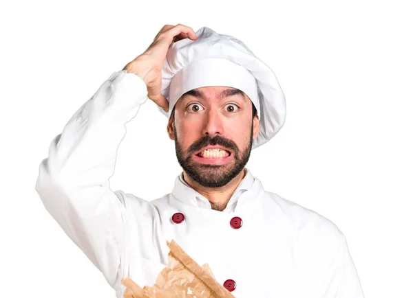 Frustrated young baker holding some bread — Stock Photo, Image