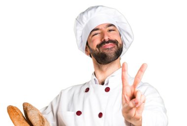 Biraz ekmek tutarak ve zafer jest yapma genç baker