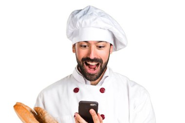 Biraz ekmek tutarak ve konuşmak için telefon genç baker