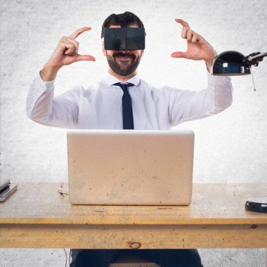 Ofisinde bir şey tutan Vr gözlükle işadamı