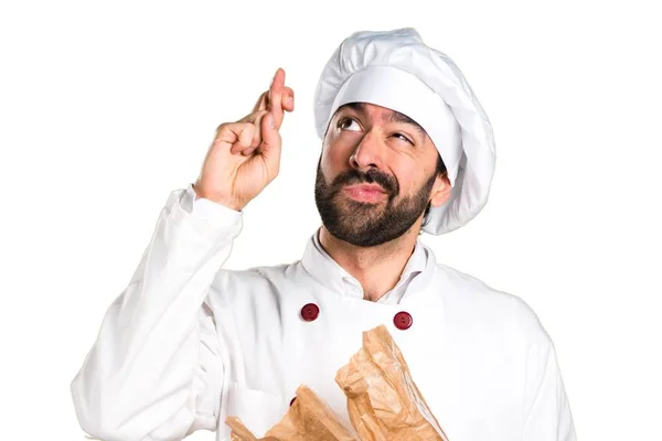 Молодий пекар тримає хліб і пальцями перетинає — стокове фото
