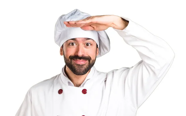 Young baker holding some bread and showing something — Stock Photo, Image