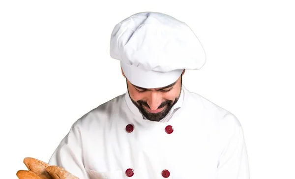 Jovem padeiro segurando um pouco de pão e olhando para baixo — Fotografia de Stock