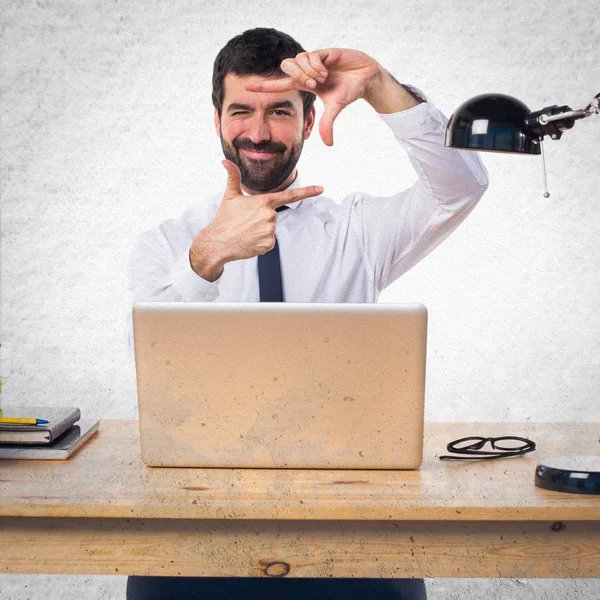 Empresário em seu escritório focando com os dedos — Fotografia de Stock