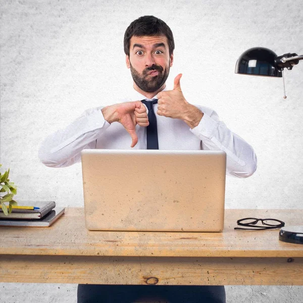 Empresario en su oficina haciendo buena o mala señal — Foto de Stock