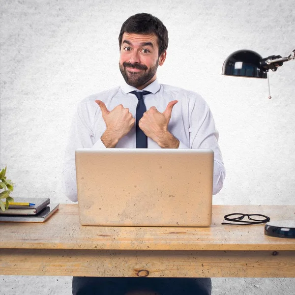 Podnikatel ve své kanceláři s palcem nahoru — Stock fotografie