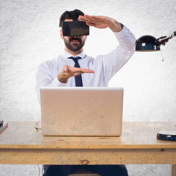 Ofisinde bir şey tutan Vr gözlükle işadamı