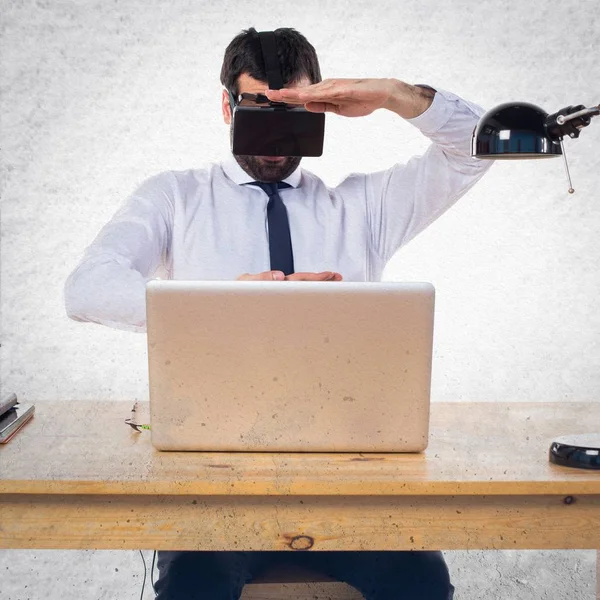 Ofisinde bir şey tutan Vr gözlükle işadamı