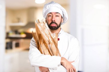 Mutfakta biraz ekmek tutan üzgün genç baker