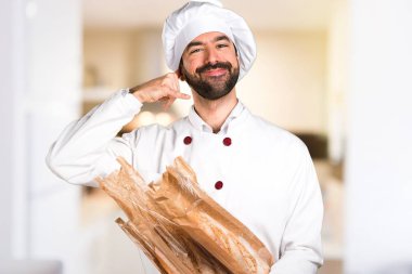 Biraz ekmek ve verme telefon jest mutfakta tutan genç baker