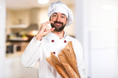 Genç baker ekmek tutan ve küçük yapma mutfakta oturum açın