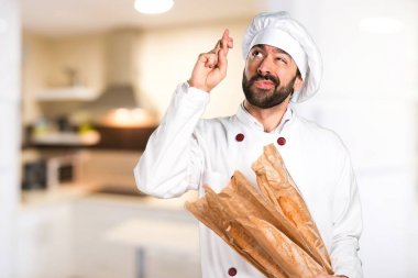 Biraz ekmek tutan genç baker ve parmaklarıyla mutfakta geçiş